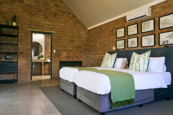 2 bedden met groene sprei in vakantiehuisje