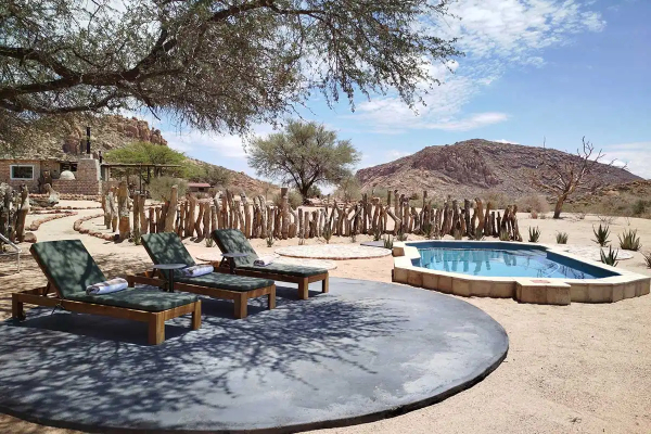 Zwembad bij Omandumba Guest Farm, met bergen op de achtergrond