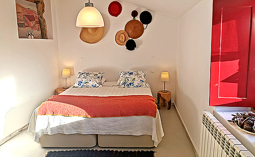 Kamer met tweeperoonsbed en hoedjes aan de muur