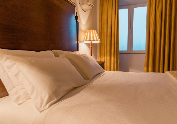 2 persoonsbed met op de achtergrond gouden gordijnen 