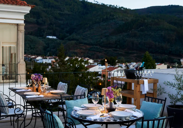 Dakterras met gedekte tafels op de voorgrond met op achtergrond het achterland van Lousa
