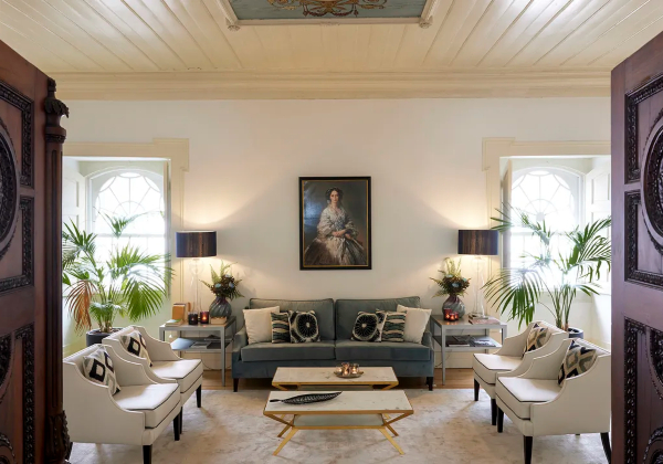 Zitkamer in het Palácio da Lousa, met witte stoelen op de voorgrond en een groene bank op de achtergrond