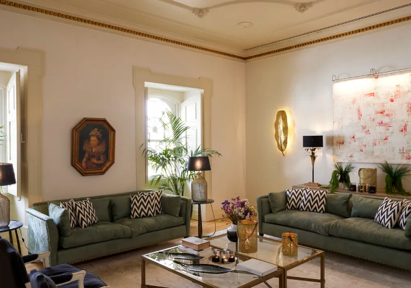 Zitkamer met groene banken en glazen tafeltje, in het Palácio da Lousa