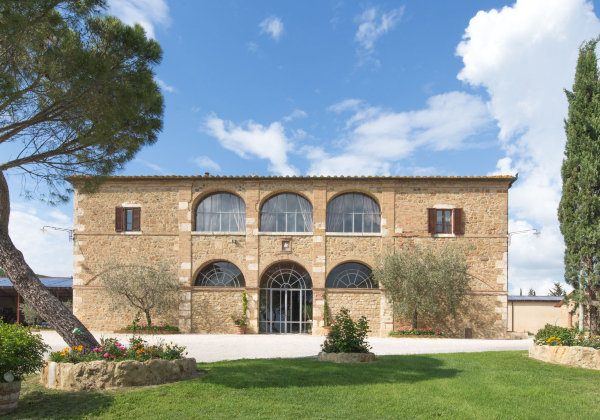 Vooraanzicht met grasveld op de voorgrond van agriturismo le Checche
