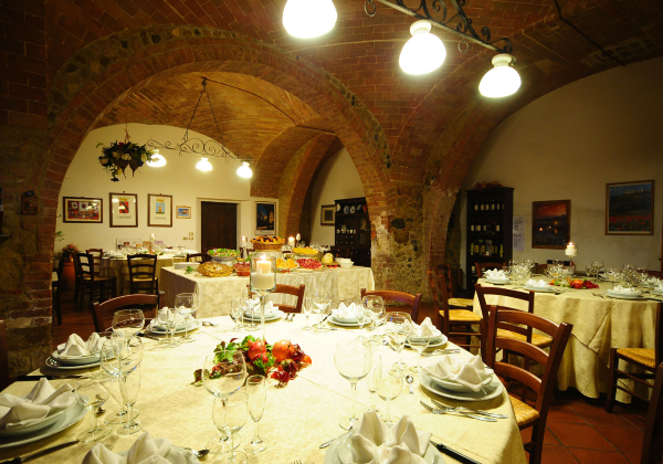 Dinerzaal in een Agriturismo, met hapjes op de achtergrond en op de voorgrond een gedekte tafel