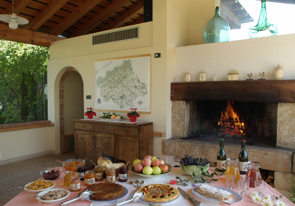 Gedekte tafel met Italiaanse lekkernijen, met haardvuur op de achtergrond