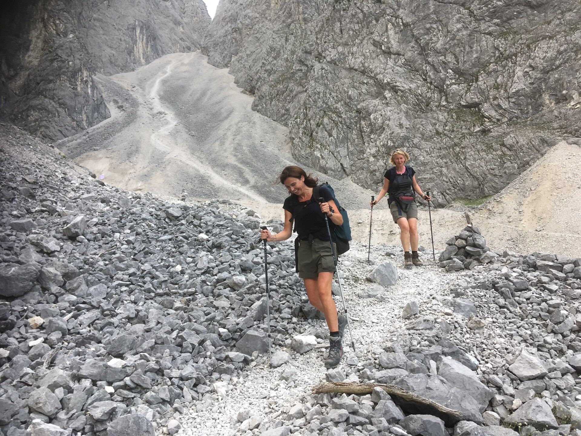 Afdaling over steengruis in de Alpen met wandelstokken