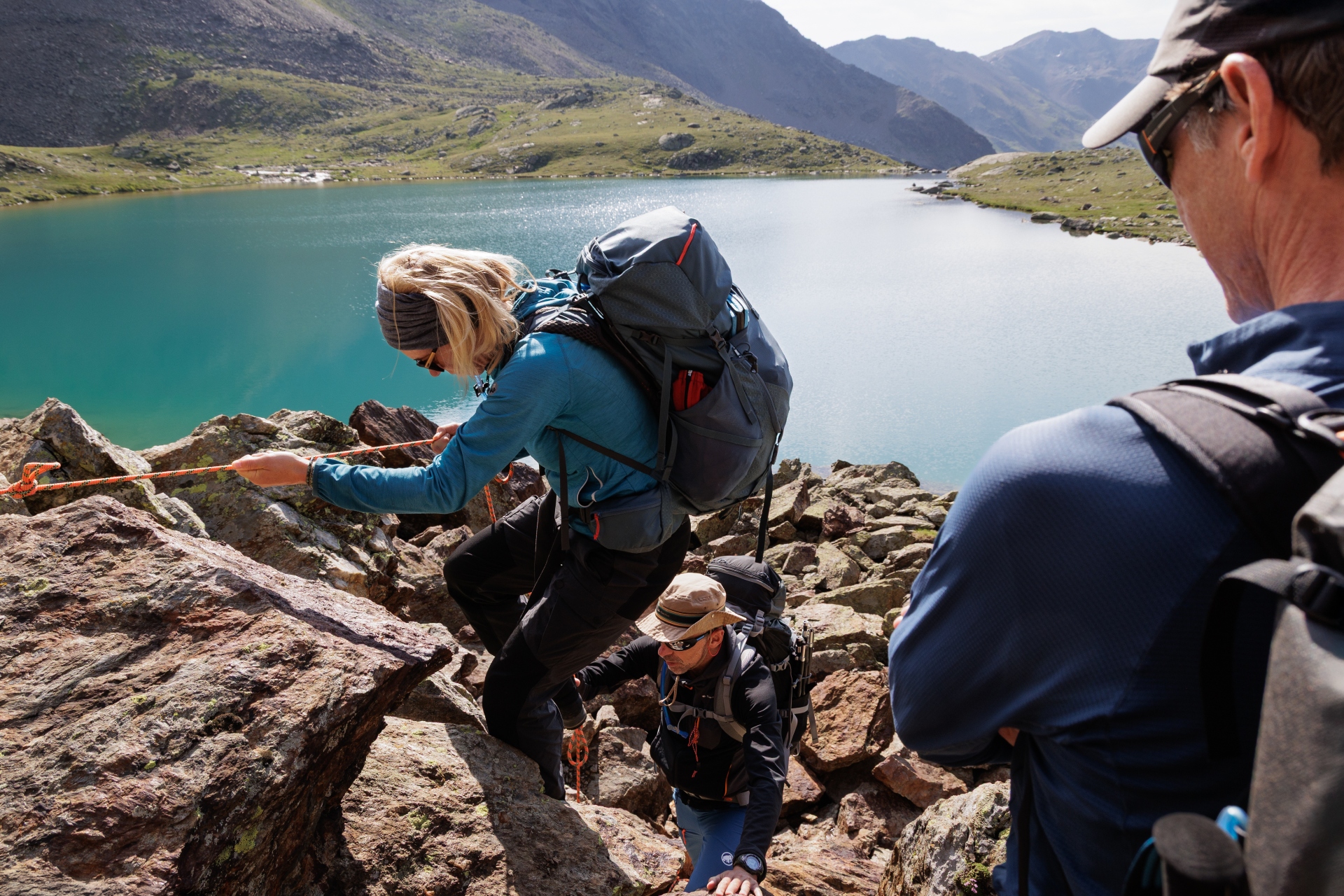 Reisleiders klimmen over rotsen langs een knopentouw in de Alpen